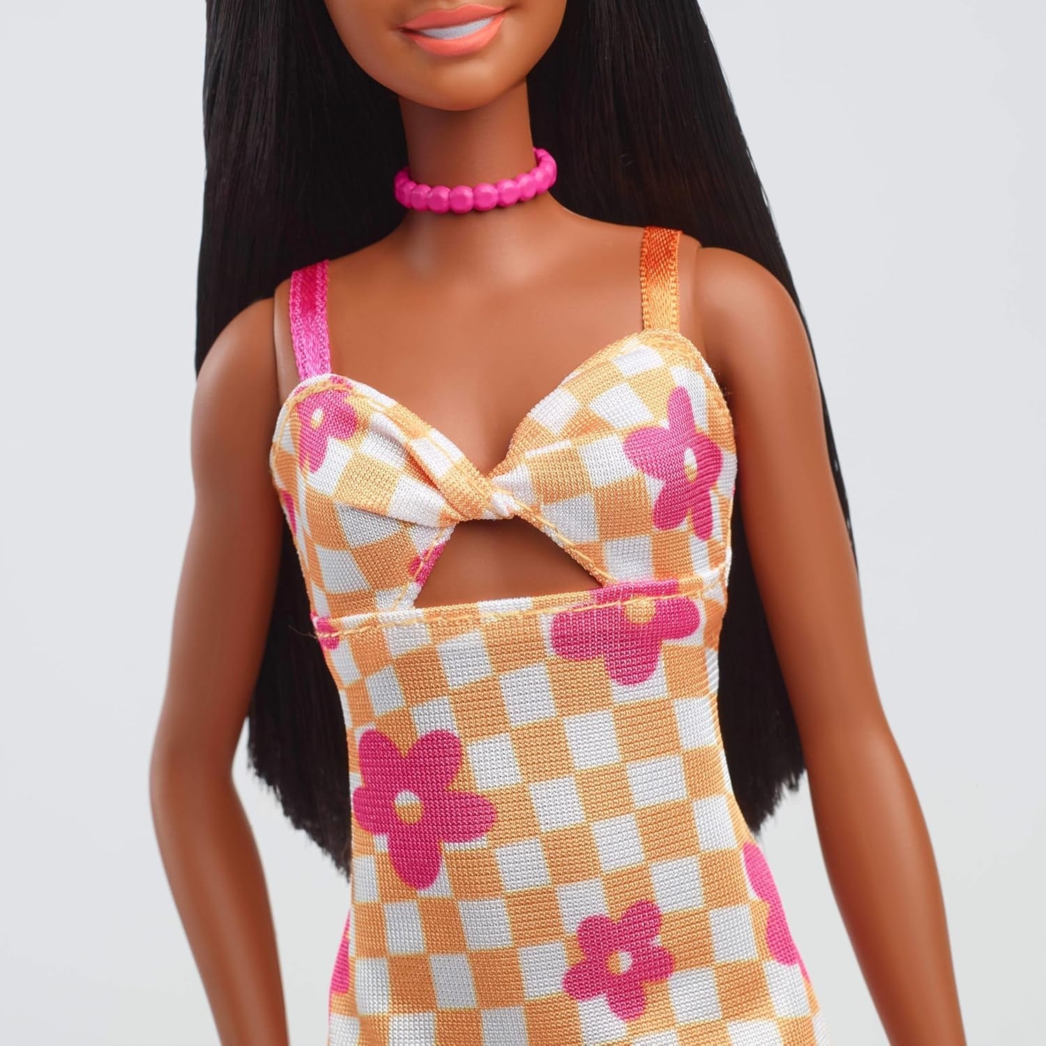 Lalka Barbie Fashionistas nr. 233 z czarnymi włosami, pomarańczową kraciastą sukienką z różowymi kwiatami, naszyjnikiem i sandałami, HYT91