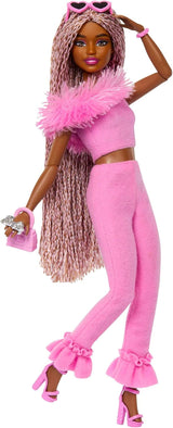 Lalka Barbie Deluxe Style nr. 3 ze strojem Barbiecore, blond włosami spiętymi w wysoki kok, pastelową różową sukienką z dużą kokardą i dodatkami takimi jak rajstopy kabaretki, HYV27 Naty Shop Brown Dolls
