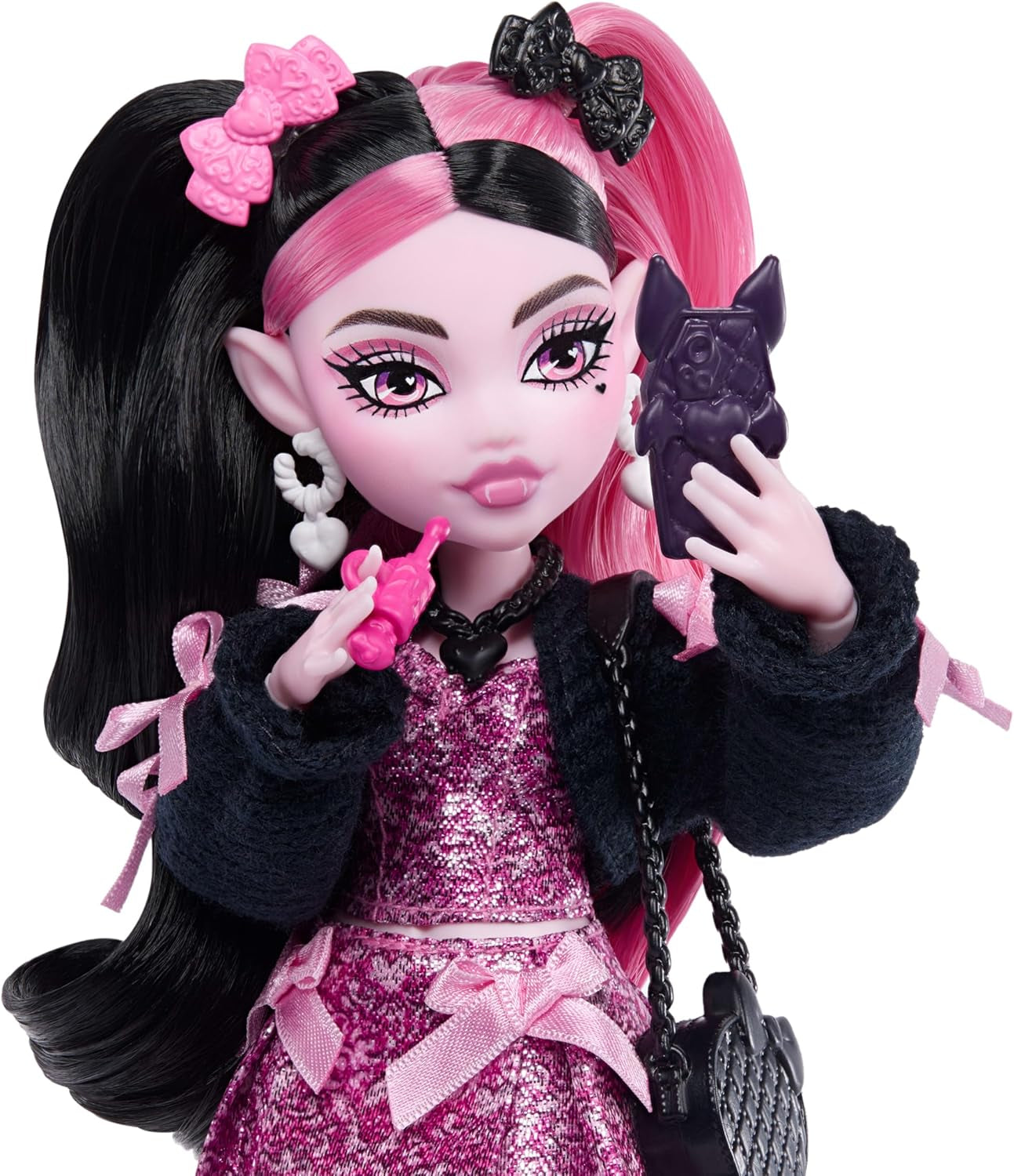 Lalka Monster High Draculaura w różowej sukience z kokardkami i czarnym kardiganie z bajecznym nietoperzem hrabią i 7 akcesoriami, w tym ramenem, szminką i torebką, JHK29