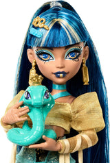Lalka Monster High Cleo De Nile w złotej bluzce i warstwowej spódnicy, zawiera zwierzątko Cobra Hissette i akcesoria, takie jak plecak, przekąska i rolka papieru, lalki HXH74 Naty Shop