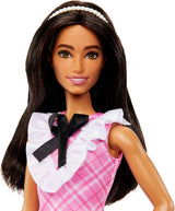 Lalka Barbie Fashionistki ze sportowymi czarnymi włosami i perłową opaską na głowie, ubrana w różową kraciastą sukienkę z czarną kokardką i marszczonym kołnierzykiem dla dzieci w wieku od 3 lat HJT06